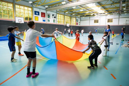 Sportler mit Schwungtuch in einer Sporthalle